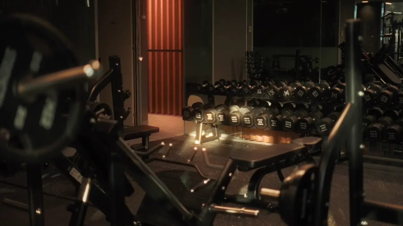 Dimly lit gym with weights and benches