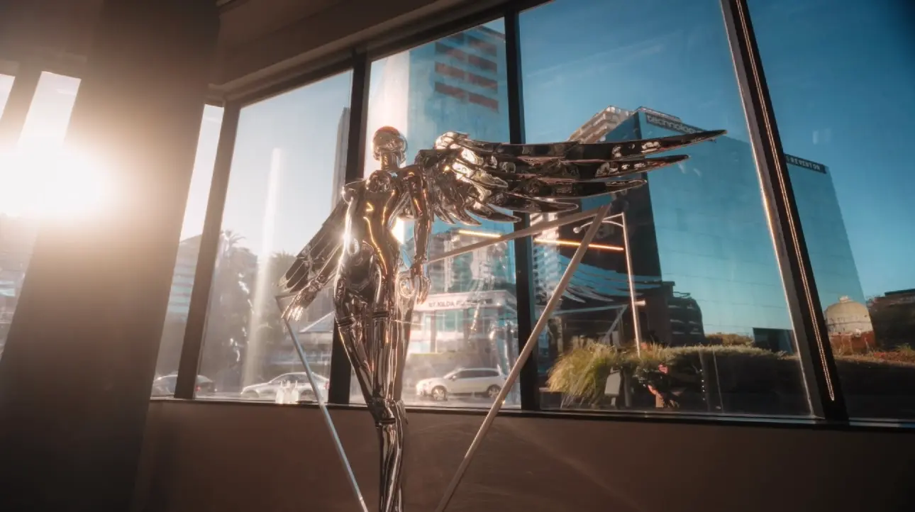 Decorative metallic winged sculpture by the window.